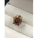 A 9ct HALLMARKED GOLD RUBY CLUSTER AND STAR BURST RING. FINGER SIZE J. WEIGHT 2.37grms.