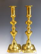 A PAIR OF LARGE VICTORIAN BRASS CANDLESTICKS WITH CENTRAL PUSHERS.