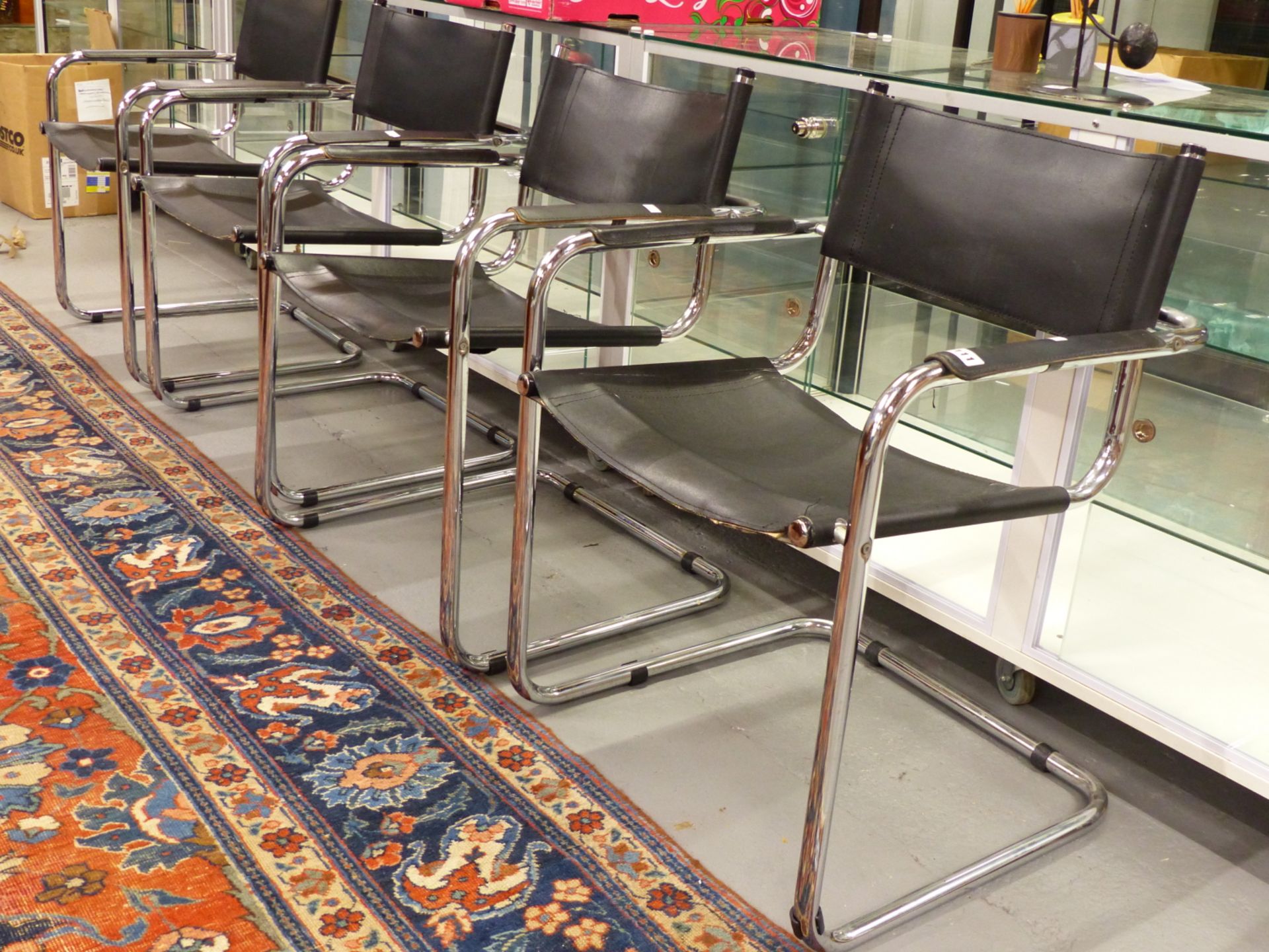 A SET OF FOUR CHROME AND LEATHER RETRO ARMCHAIRS AFTER A DESIGN BY MARCEL BREUER.