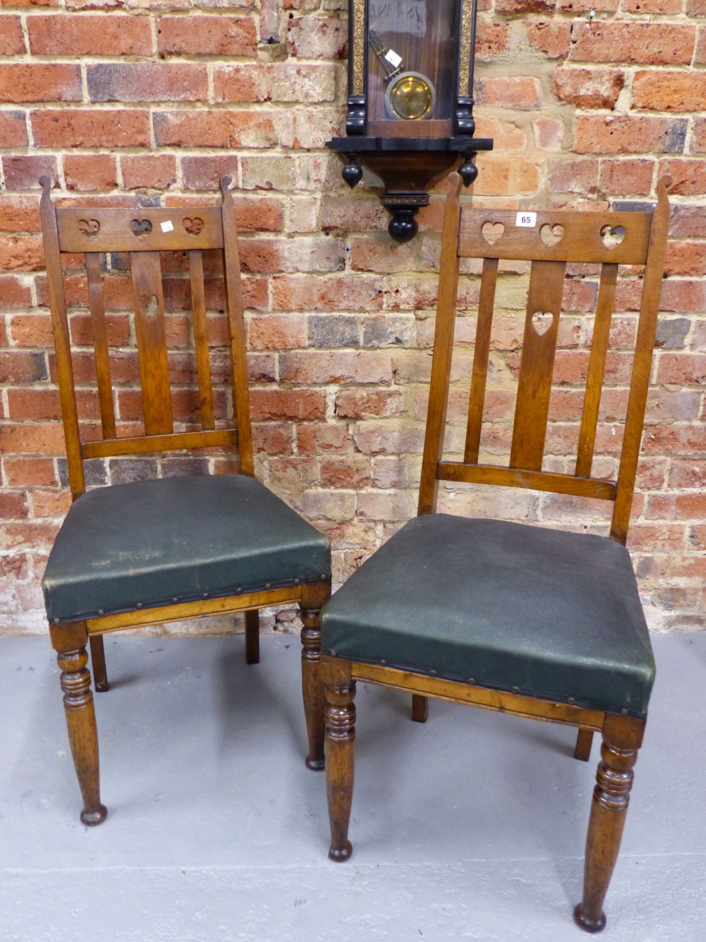 A PAIR OF EARLY 20th CENTURY ARTS AND CRAFTS STYLE OAK DINING CHAIRS WITH PIERCED HEART BACKS AND