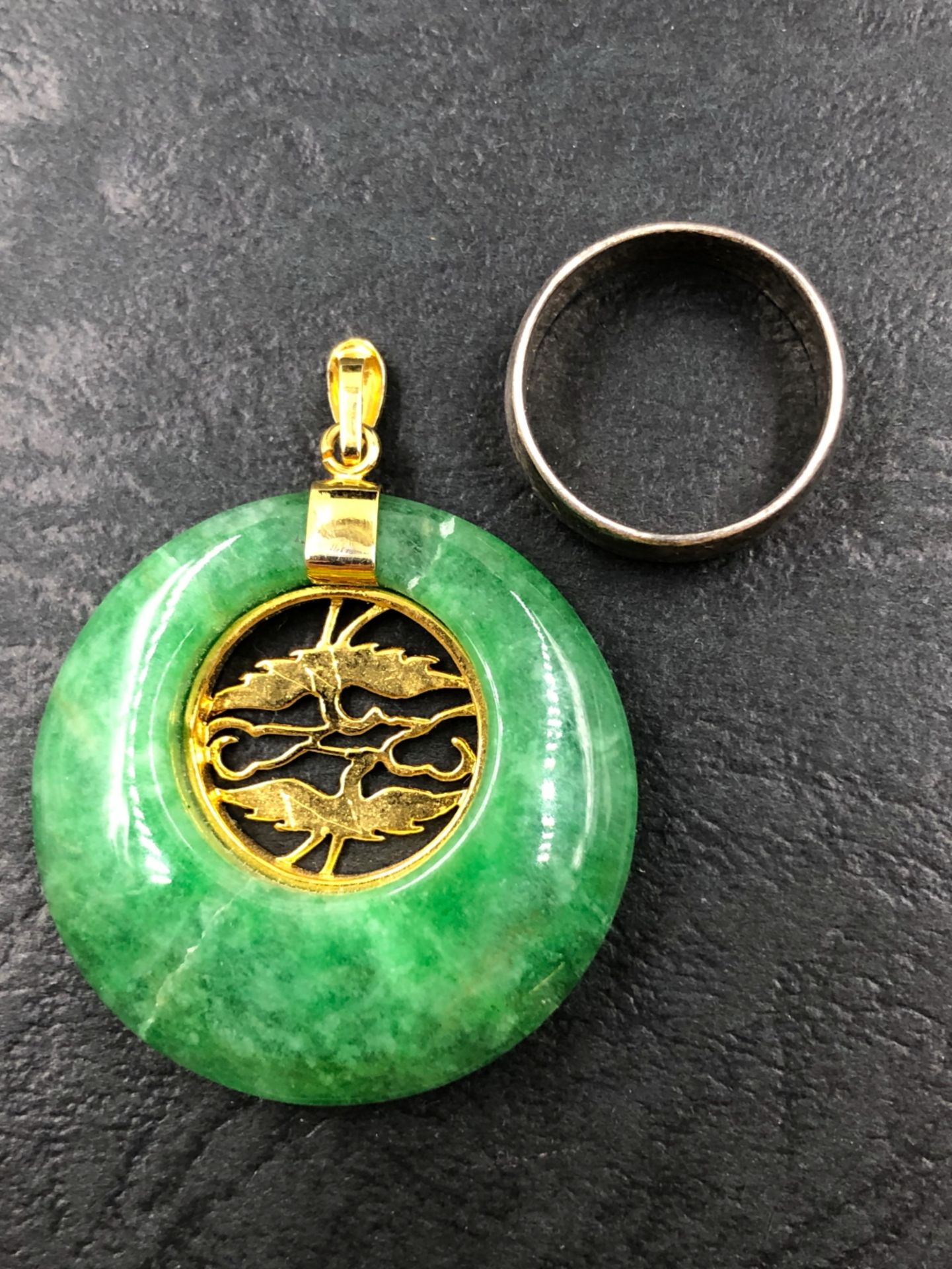 AN ORIENTAL GREEN HARDSTONE PENDANT TOGETHER WITH AN UNHALLMARKED SILVER BAND, FINGER SIZE J 1/2 - Bild 2 aus 2
