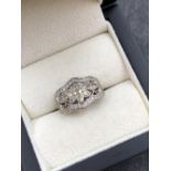 A DIAMOND SET FOLIATE STYLE PANEL RING. THE RING WITH A CENTRAL MARQUISE CUT SIX LEAF CLUSTER WITH