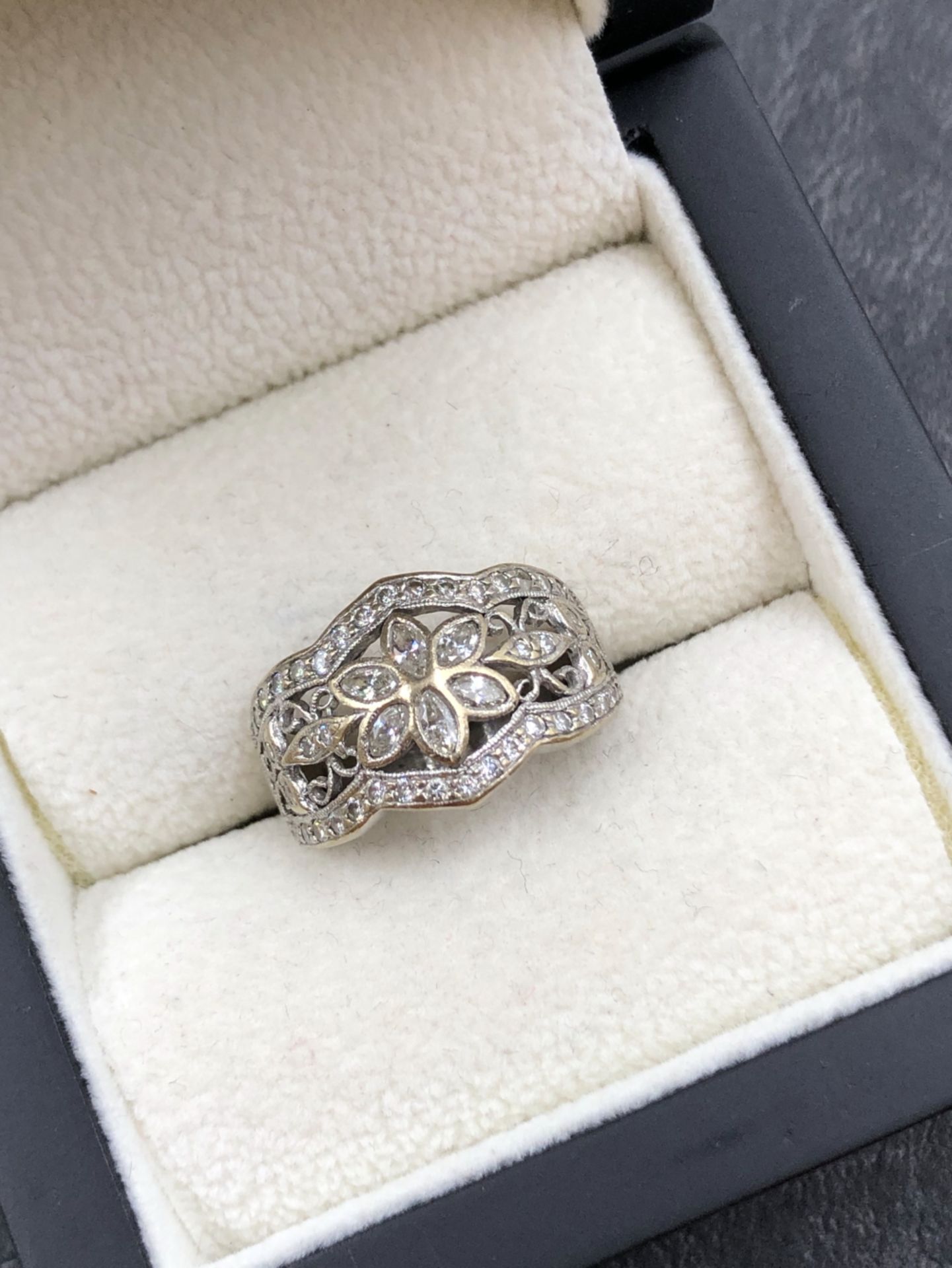 A DIAMOND SET FOLIATE STYLE PANEL RING. THE RING WITH A CENTRAL MARQUISE CUT SIX LEAF CLUSTER WITH