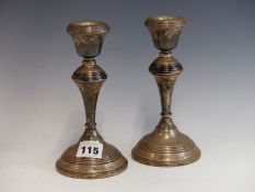 A PAIR OF HALLMARKED SILVER LOADED CANDLESTICKS.