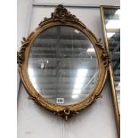 AN ORNATE GILT FRAMED OVAL MIRROR 68 x 45cm