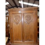 A GOOD QUALITY CARVED OAK SMALL CORNER CABINET
