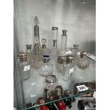 A COLLECTION OF SILVER MOUNTED CLEAR GLASS SCENT AND DRESSING TABLE BOTTLES