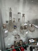 A COLLECTION OF SILVER MOUNTED CLEAR GLASS SCENT AND DRESSING TABLE BOTTLES