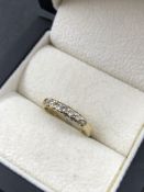 A 9ct HALLMARKED GOLD AND SEVEN STONE DIAMOND HALF ETERNITY RING, APPROXIMATE DIAMOND WEIGHT 0.