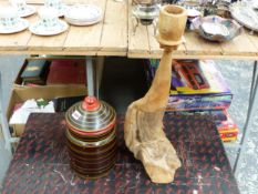 AN INDIAN PAINTED HARDWOOD JAR AND COVER AND A WEATHERED WOOD CANDLE STAND.