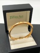 A VINTAGE HINGED BANGLE. STAMPED 15, NO ASSAY MARKS, ASSESSED AS 15ct GOLD. WEIGHT 10.45grms.
