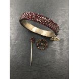 AN ANTIQUE BOHEMIAN GARNET BANGLE, A SIMILAR TARGET BROOCH, AND A STICK PIN, ASSESSED AS BASE