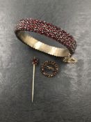 AN ANTIQUE BOHEMIAN GARNET BANGLE, A SIMILAR TARGET BROOCH, AND A STICK PIN, ASSESSED AS BASE