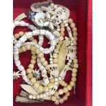 AN ANTIQUE SNAKE SPINE NECKLACE, A CARVED BONE NECKLACE, A CARVED BEADED EXAMPLE, FLOWER BROOCHES,