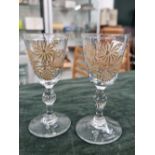 A PAIR OF 18th CENTURY CORDIAL GLASSES THE ENGRAVED BOWLS WITH GILT FLORAL DECORATION, ON BOBBIN