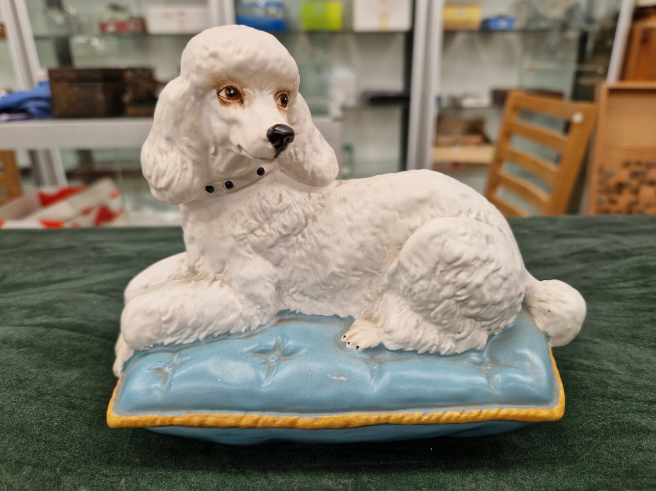 A BESWICK POTTERY WHITE POODLE ON A CUSHION MARKED TO BASE.