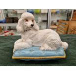 A BESWICK POTTERY WHITE POODLE ON A CUSHION MARKED TO BASE.