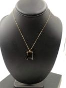 A VINTAGE SMOKY QUARTZ PENDANT IN A FOUR CLAW PENDANT MOUNT, SUSPENDED ON A 42cm CHAIN. NO ASSAY