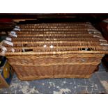 A LARGE WICKER LAUNDRY HAMPER.