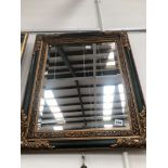 A GILT AND BLACK FRAMED MIRROR 68 x 54cm