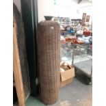 A TALL CYLINDRICAL FISHING BASKET