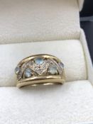 A 9ct HALLMARKED GOLD GEMSET AND DIAMOND RING. THE SETTING WITH FIVE CLAW SET LIGHT BLUE GEMS AND