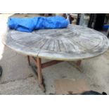 A LARGE CIRCULAR TEAK GARDEN TABLE.