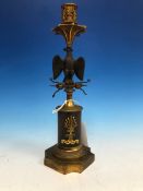 A 19th C. FRENCH PARCEL GILT BRONZE CANDLESTICK, THE NOZZLE SUPPORTED ON A SPREAD EAGLE PERCHED ON