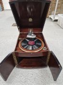 A MAHOGANY CASED THREE MUSES WIND UP GRAMOPHONE WITH DOORS BELOW THE TURNTABLE TO RELEASE THE SOUND