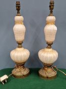 A PAIR OF GILT METAL MOUNTED VENETIAN PINK GLASS TABLE LAMPS, THE GLASS RIBBED AND GILT WITH ROUND
