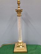 A BRASS MOUNTED CLEAR GLASS SPIRAL COLUMNAR TABLE LAMP WITH CORINTHIAN CAPITAL AND STEPPED SQUARE
