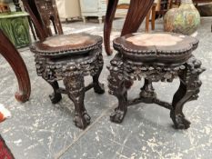 A PAIR OF CHINESE CARVED HARDWOOD THREE LEGGED STANDS WITH MOTTLED PINK MARBLE INSET TOPS. W 27 x