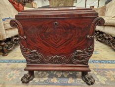 A 19th C. MAHOGANY CELLARETTE WITH A HINGED LID TO THE SARCOPHAGUS SHAPE CARVED WITH FOLIAGE AT