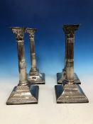 A SET OF FOUR SILVER STOP FLUTED COLUMN CANDLESTICKS BY SH, LONDON 1893, EACH RAISED ON SQUARE
