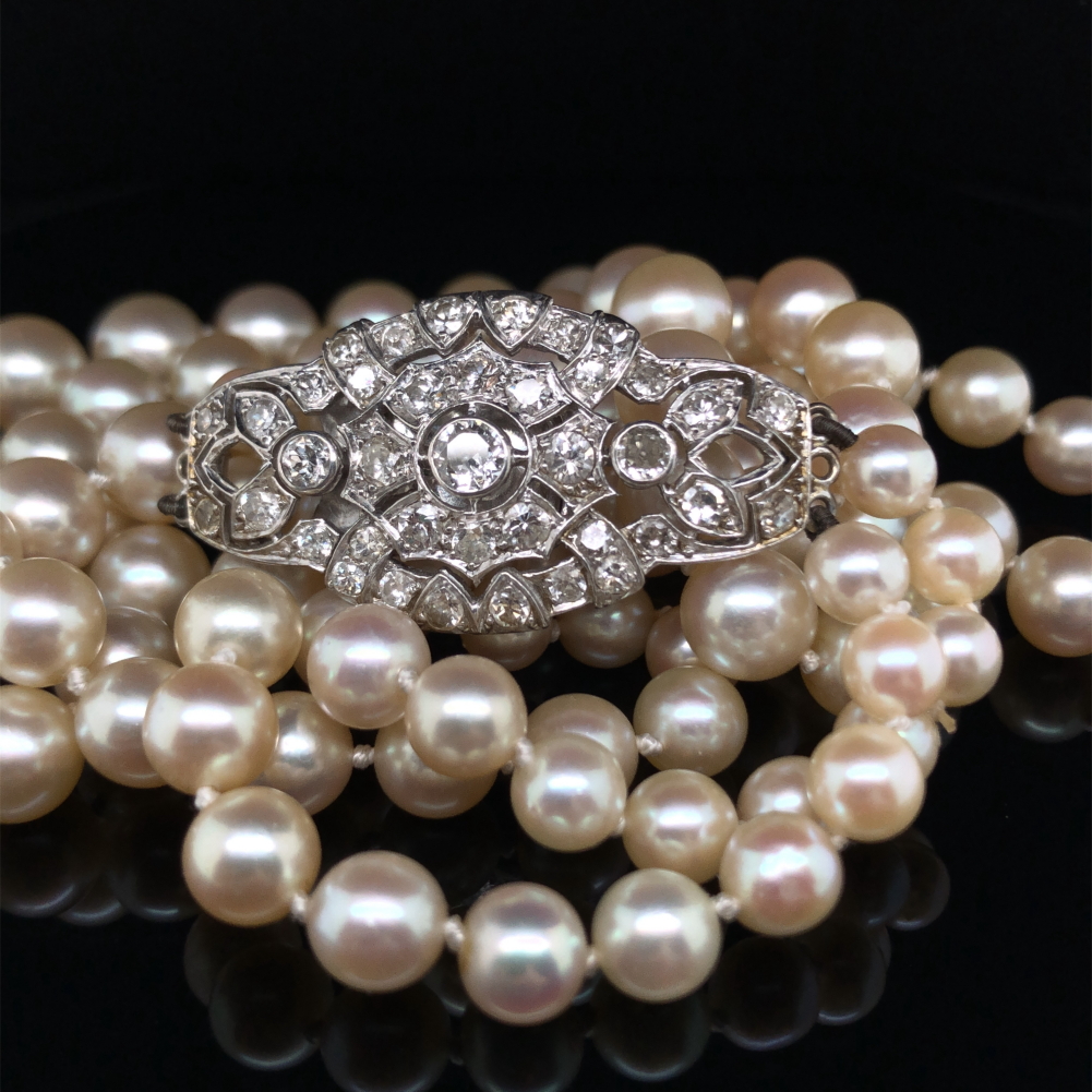 A TWO ROW GRADUATED CULTURED FRESHWATER PEARL NECKLACE COMPLETE WITH AN ORNATE DIAMOND SET CLASP.