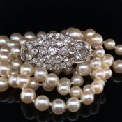 A TWO ROW GRADUATED CULTURED FRESHWATER PEARL NECKLACE COMPLETE WITH AN ORNATE DIAMOND SET CLASP.