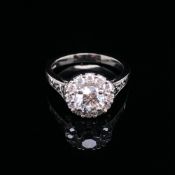 A GIA ROUND BRILLIANT CUT DIAMOND AND PLATINUM RING. THE CENTRE DIAMONDS 0.71cts, SURROUNDED BY A