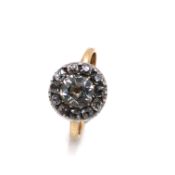 AN ANTIQUE DIAMOND RING WITH CENTRAL CUSHION OLD CUT DIAMOND WITHIN AN ELEVEN STONE HALO SURROUND,