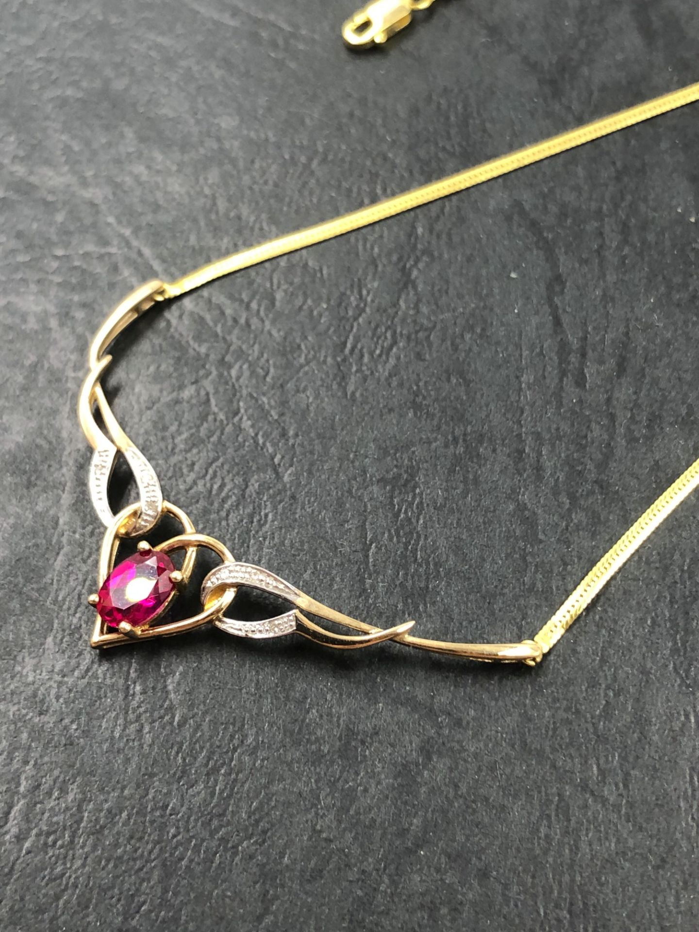 A HALLMARKED 9ct GOLD RUBY AND DIAMOND NECKLACE. THE OVAL CUT RUBY MEASUREMENTS 7.0 X 5.0 D 3.4mm. - Image 3 of 3