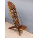 AN AFRICAN CARVED HARDWOOD "BIRTHING" CHAIR.