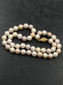 A CULTURED PEARL NECKLACE OF FOUR VARIOUS HUES. THE NECKLACE LENGTH APPROXIMATELY 39.5cms,
