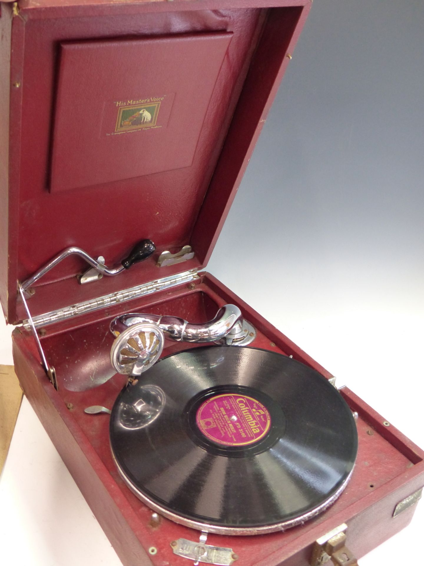 A VINTAGE HMV (HIS MASTERS VOICE) PORTABLE GRAMOPHONE IN RARE RED LETHERETTE COVERED OUTER.