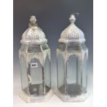 A PAIR OF PAINTED HEXAGONAL PIERCED METAL AND GLASS HANGING CANDLE LANTERNS.