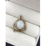 A VINTAGE OVAL OPAL PENDANT IN AN RUB OVER AND STYLISED SETTING. THE BAIL STAMPED 9ct EH. ASSESSED