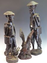 TWO AFRICAN HARDWOOD STANDING FIGURES, A PAIR OF HEADS, A RELIEF CARVED PLAQUE, A TABLE LAMP PIERCED