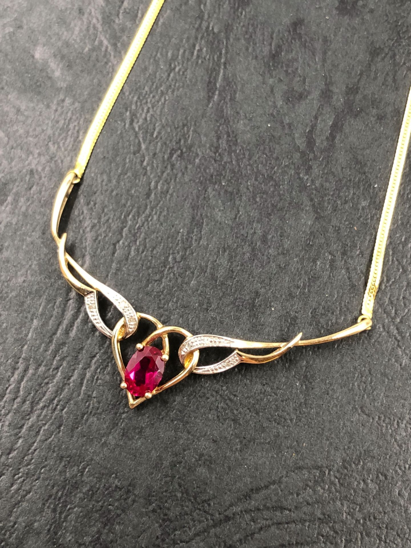 A HALLMARKED 9ct GOLD RUBY AND DIAMOND NECKLACE. THE OVAL CUT RUBY MEASUREMENTS 7.0 X 5.0 D 3.4mm.