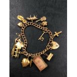 A VINTAGE 9ct GOLD CHARM BRACELET WITH A VARIETY OF 9ct AND 18ct ATTACHED CHARMS. GROSS WEIGHT 42.