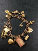 A VINTAGE 9ct GOLD CHARM BRACELET WITH A VARIETY OF 9ct AND 18ct ATTACHED CHARMS. GROSS WEIGHT 42.