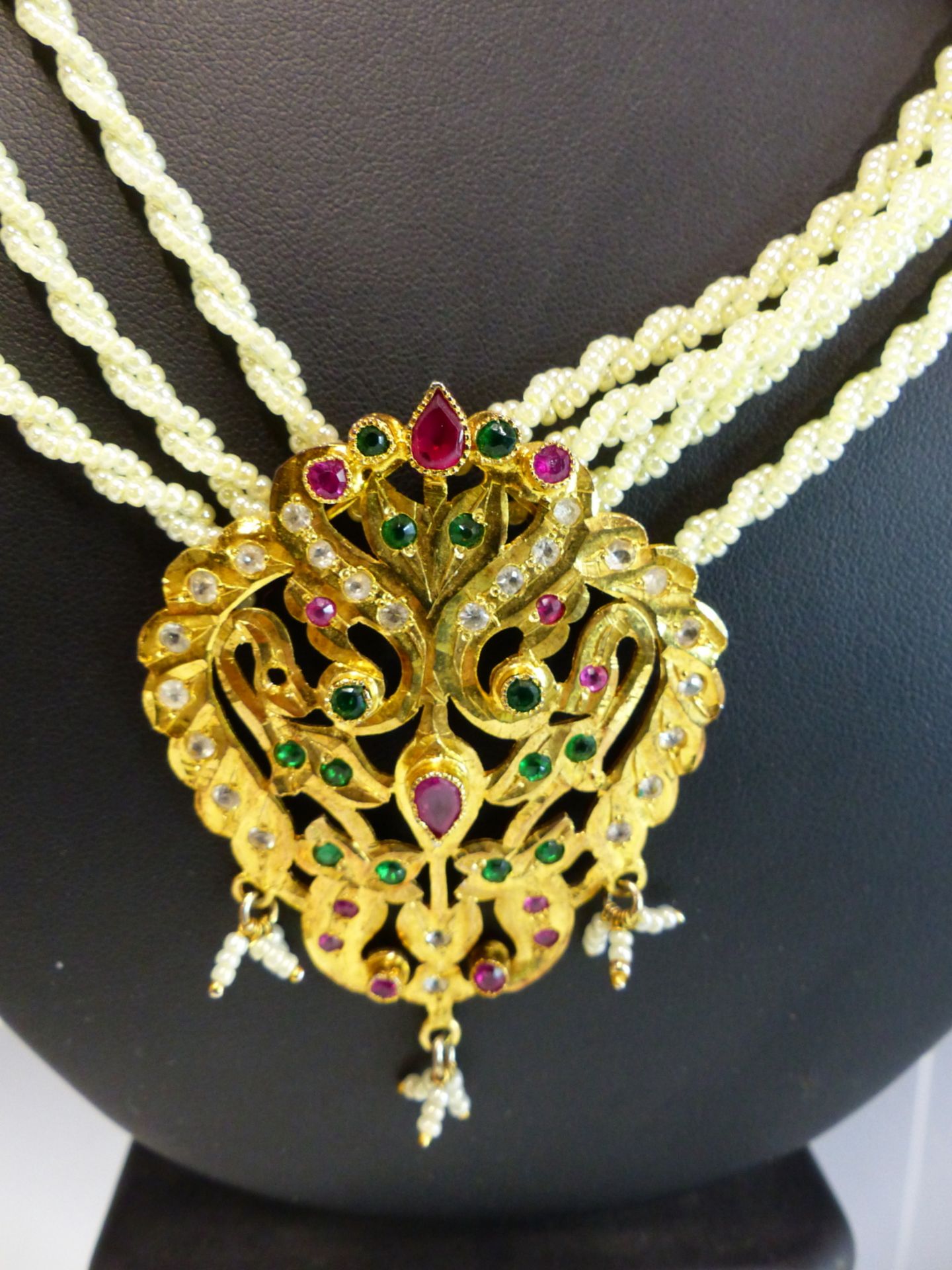 AN EASTERN NECKLACE THE GILDED PENDANT SET WITH COLOURED PASTE STONES SUSPENDED ON A WOVEN PEARL - Image 3 of 3