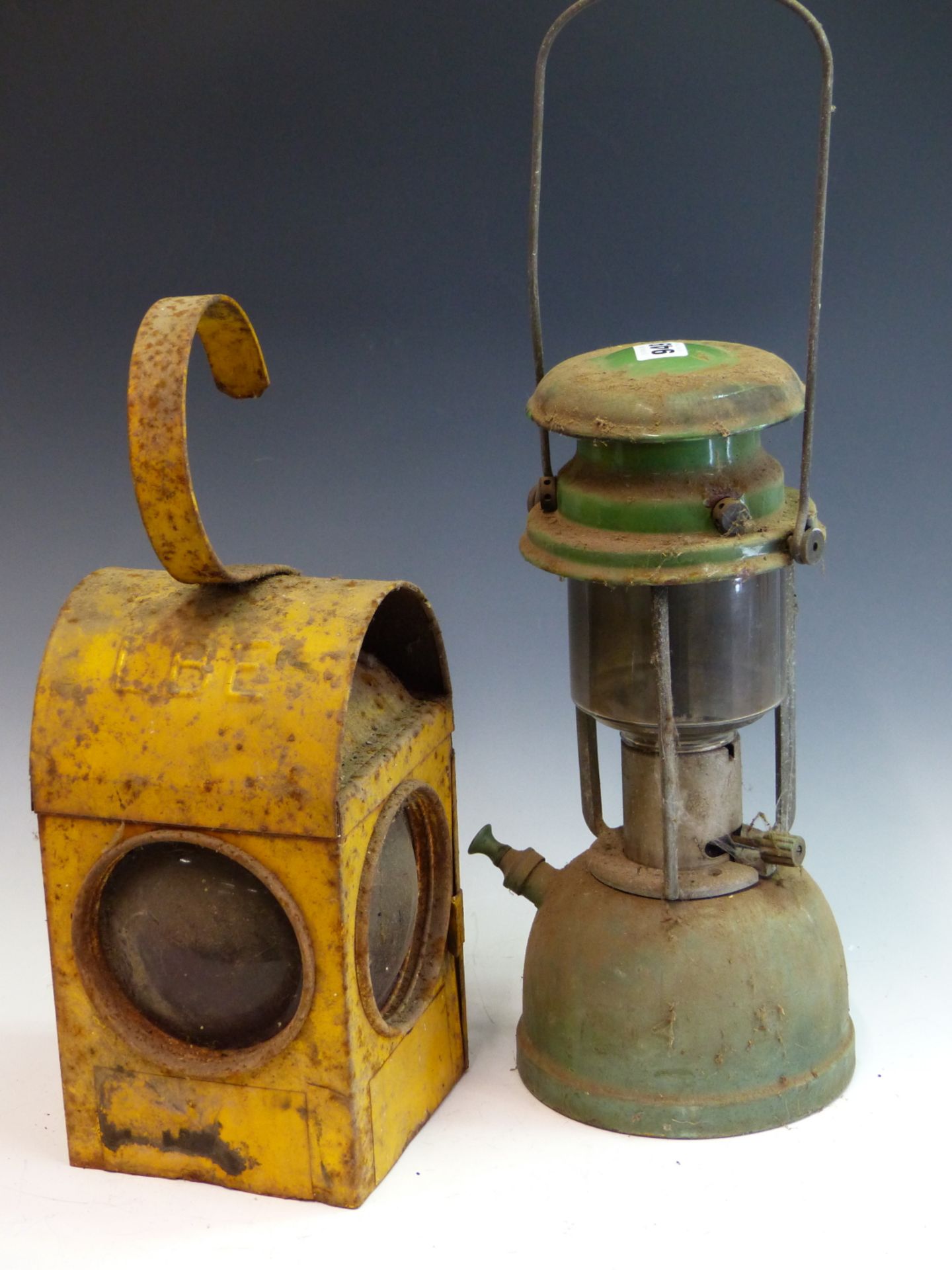 A VINTAGE TILLY LANTERN, 4 HURRICANE STORM LAMPS, A YELLOW PAINTED ROADWORKERS WARNING LIGHT AND ONE